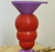 a purple funnel atop a red kong dog toy, sitting on a purple Stopple toy stand