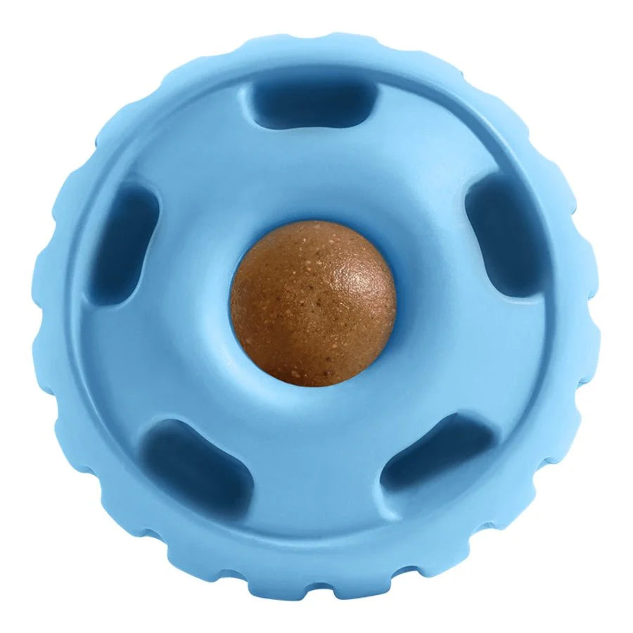 A blue round rubber fillable dog toy with a brown treat in the center