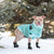 Light tan pit bull-type dog wearing light aqua puffer standing in snow