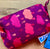 Fuchsia rain poncho for dogs with raincloud print packed inside carrying bag 