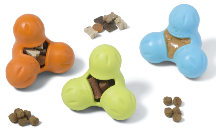 an orange, a blue and a green treat dispensing dog toy and three piles of dog treats