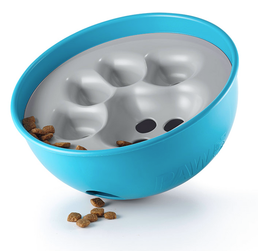 a blue and white rocking slow feeder bowl with paw print shaped indentation inside containing some pieces of dog food