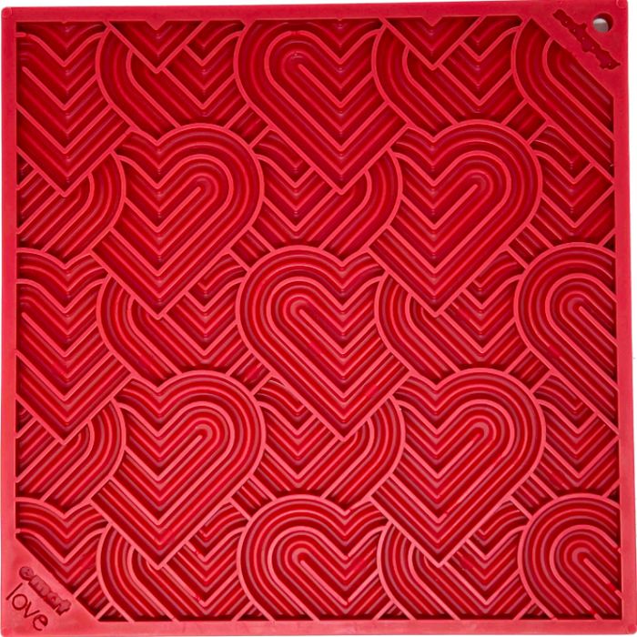 a red silicone lick mat with a heart pattern on it