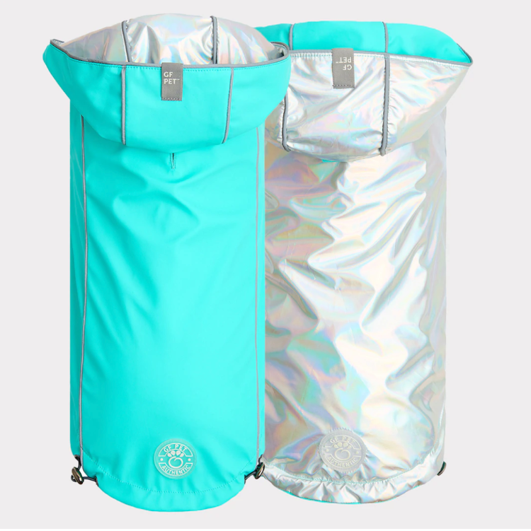 Aqua rain jacket for dogs next to iridescent silver rain jacket for dogs, both show different sides of the same product.