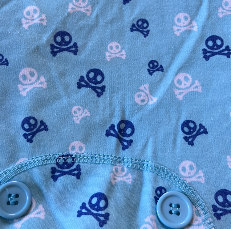 a closeup of blue fabric with skull & crossbone print