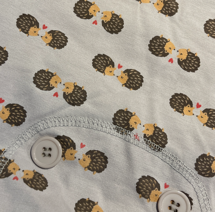 a closeup of grey fabric with kissing hedgehog print