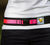 a closeup of a woman wearing a white shirt, black shorts and a neon pink and black leash belt