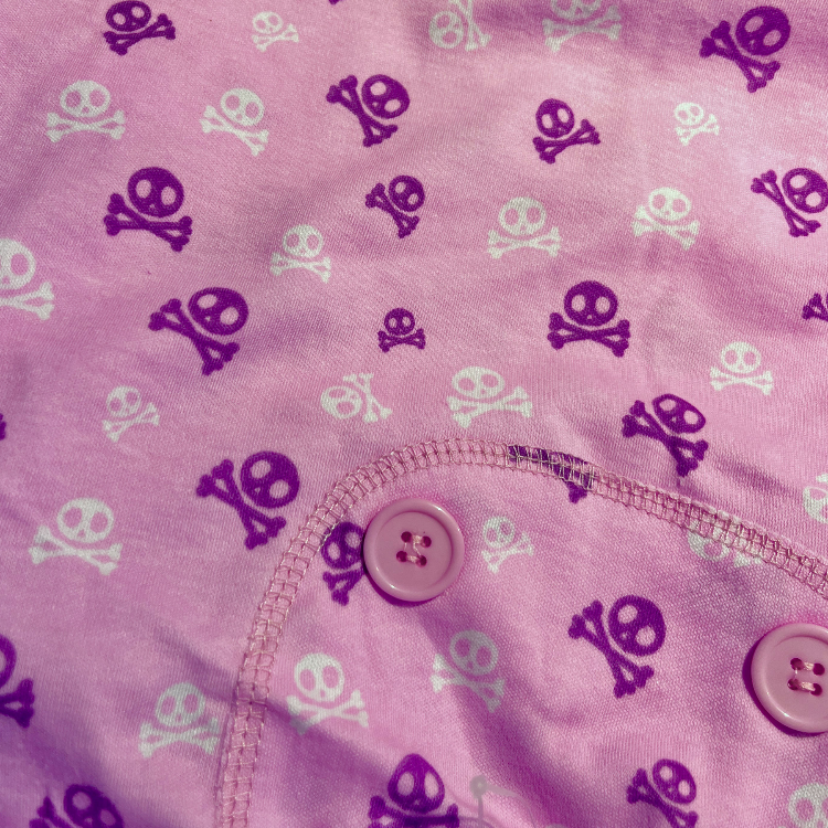 a closeup of pink fabric with skull & crossbone print